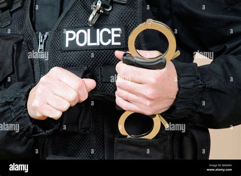 Police officer holding handcuffs Stock Photo - Alamy