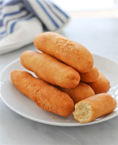 some bread sticks on a white plate with a blue and white towel in the ...