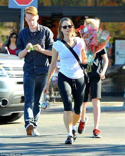 a man and woman walking down the street with flowers