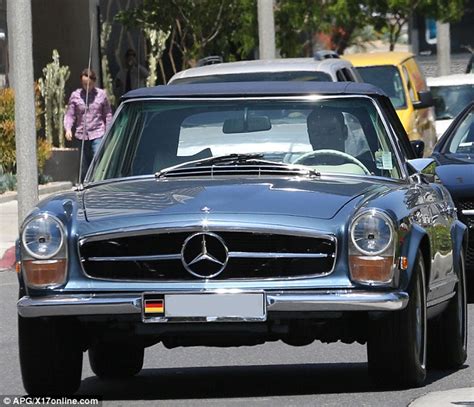 John Travolta takes one of his prized vintage cars out for a spin as he ...