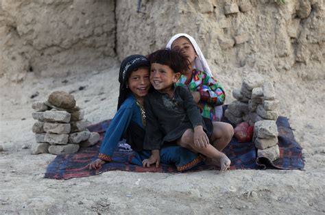 Afghan children sit outside their makeshift house at a refugee camp in ...