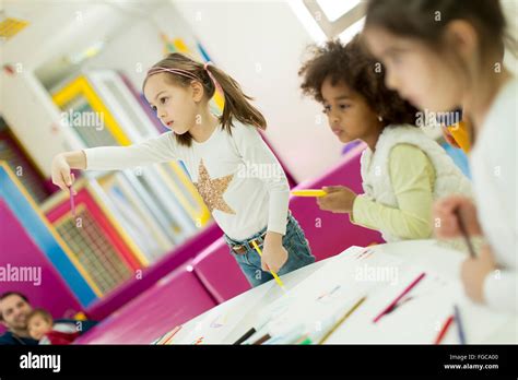 Multiracial children drawing in the playroom Stock Photo - Alamy