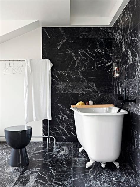 a white bath tub sitting next to a black wall