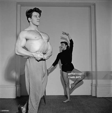 English bodybuilder Reg Park flexes his muscles as his wife, South ...