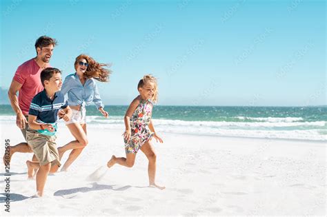 Happy family running on beach Stock 写真 | Adobe Stock