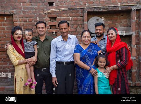 Portrait of lower middle class family standing together in the backyard ...