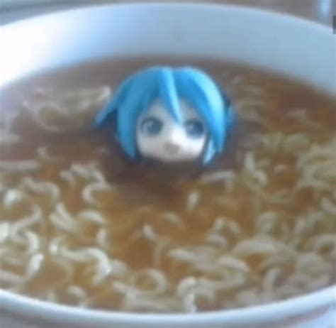 a bowl of ramen with a doll in it