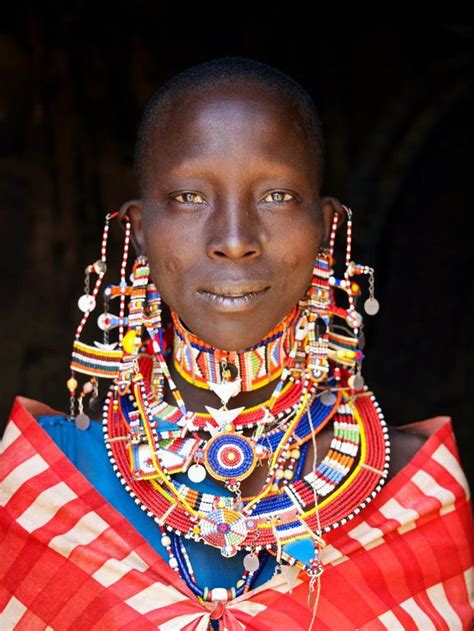 Intricate beading flows around a Maasai tribeswoman dressed in ...