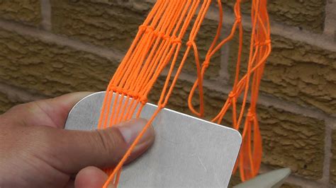 A close up of how to tie the netting knot when sewing the main net ...