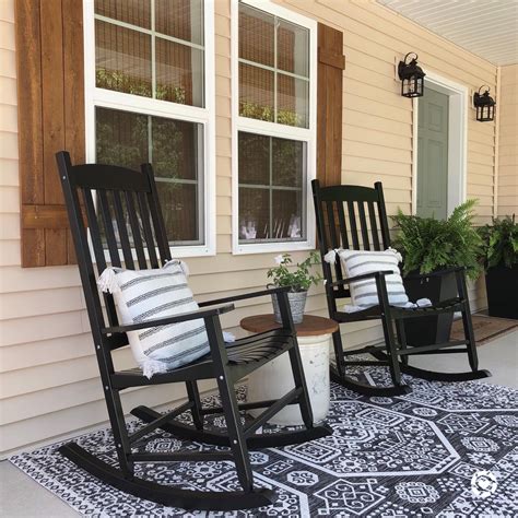 two rocking chairs sitting on top of a black and white rug