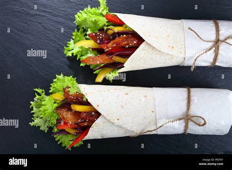 close-up of delicious fresh juicy flatbread sandwich wraps with frisee ...