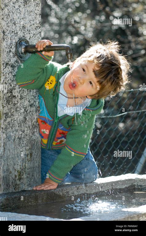 A little boy drinking from a water fountain in the park Stock Photo - Alamy