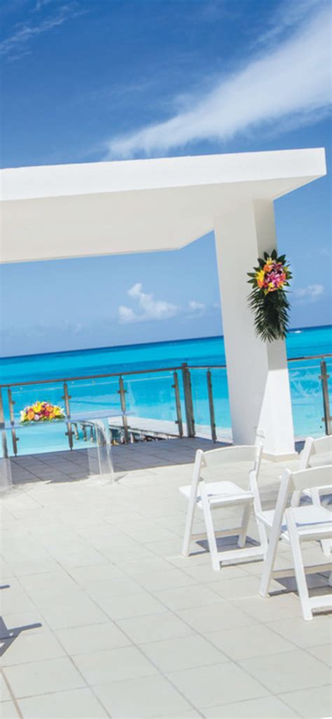 an outdoor dining area overlooking the ocean with white tables and ...