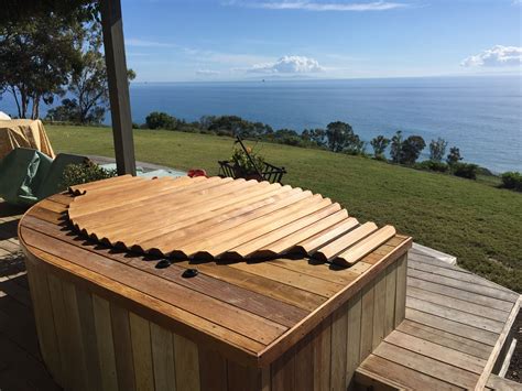 Redwood hot tub, seated in a deck, with a wooden roll-top cover. | Hot ...