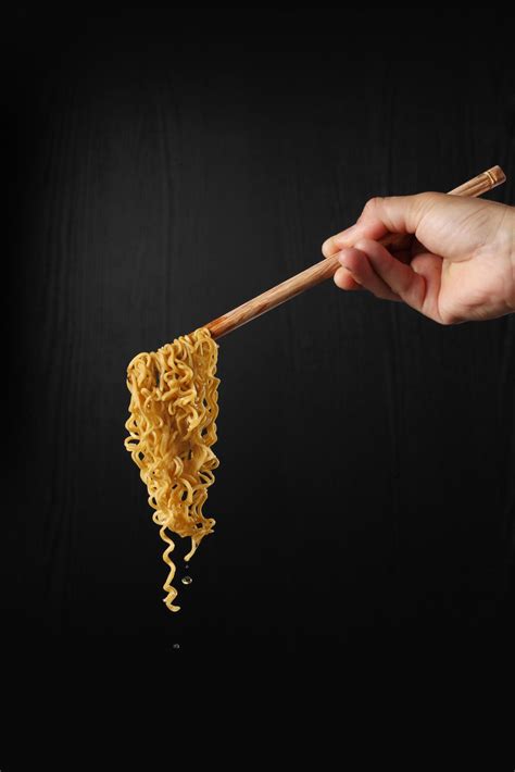 Hand holding chopsticks and noodles on black background 4732516 Stock ...