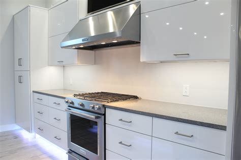 Glossy white contemporary cabinetry with quartz countertops and LED ...