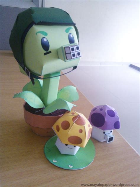 an origami sculpture of a woman with a camera on top of a potted plant