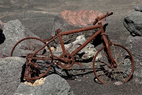 Rusty bike among boulders - Stock Photo - Dissolve