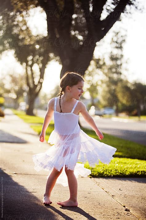 Young Girl Wearing White Slip Dress Twirling On Sidewalk by Dina Marie ...