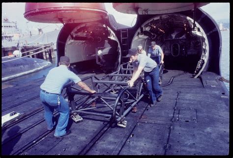 Crew members loading the hangars of the USS Grayback (SSG-574) c. 1979 ...