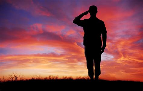 Soldier full body silhouette saluting gesture at sunset copy space ...