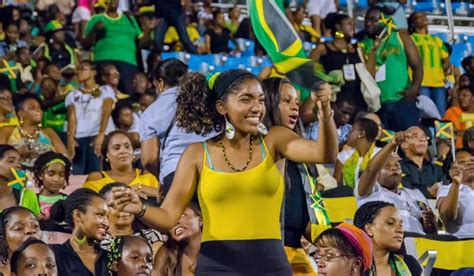 two women in yellow and black dresses are waving flags at a sporting ...