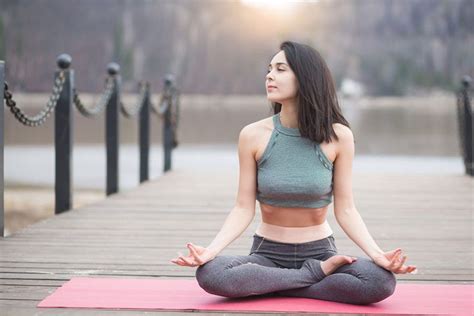 a woman is sitting in the middle of a yoga pose