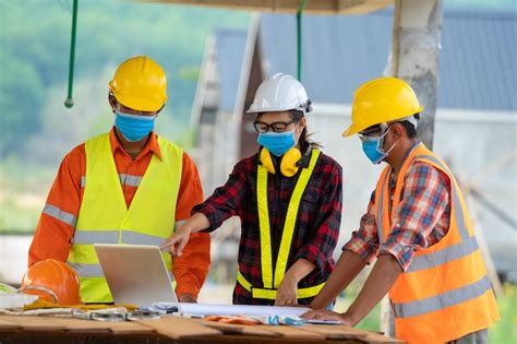 Premium Photo | Builders wearing safety helmet with blueprint at ...