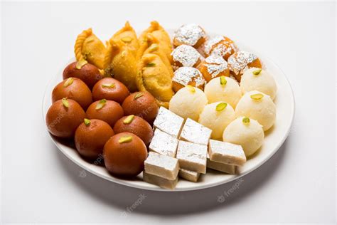 Premium Photo | Indian sweets in a plate includes Gulab Jamun, Rasgulla ...