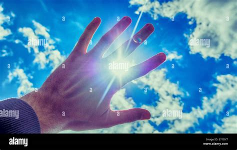 Blinding sun between the fingers Stock Photo - Alamy