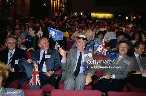 View of Conservative Party supporters as they smile and wave flags ...