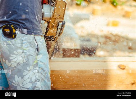 Man with a chainsaw cutting a tree for construction Stock Photo - Alamy