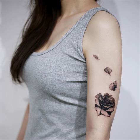 Rose blooming tattoo on the left upper arm.