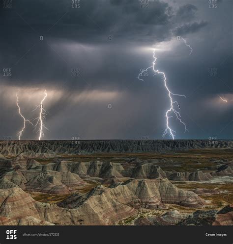 Lightning over Badlands National Park at night stock photo - OFFSET