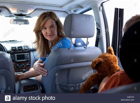 Mother turning around to child in car Stock Photo - Alamy