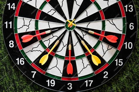 Premium Photo | Winner yellow dart arrow hit the center target of ...