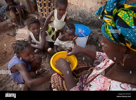 Children watch while their mother cooks food in a slum in Bamako Stock ...