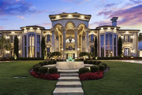 a large house with lots of windows and lights on it's front lawn area