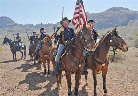 the men are riding horses with flags on their backs