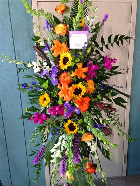 Colorful standing funeral Spray with sunflowers, orange roses and ...