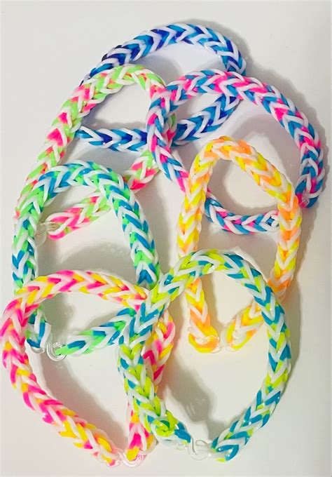 multicolored bracelets are arranged in a circle on a white surface with ...