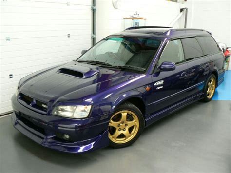 a blue car parked in a garage with yellow rims