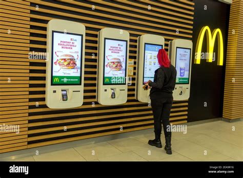 A young woman chooses a menu at a self-service order kiosk McDonalds ...