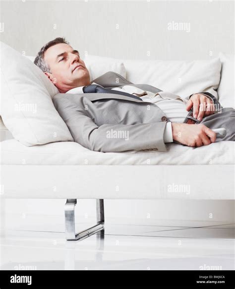 Businessman resting on couch Stock Photo - Alamy