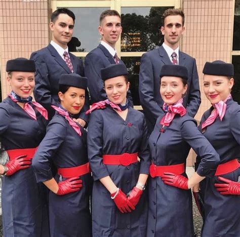 the cabin crew is posing for a group photo in front of an airport ...