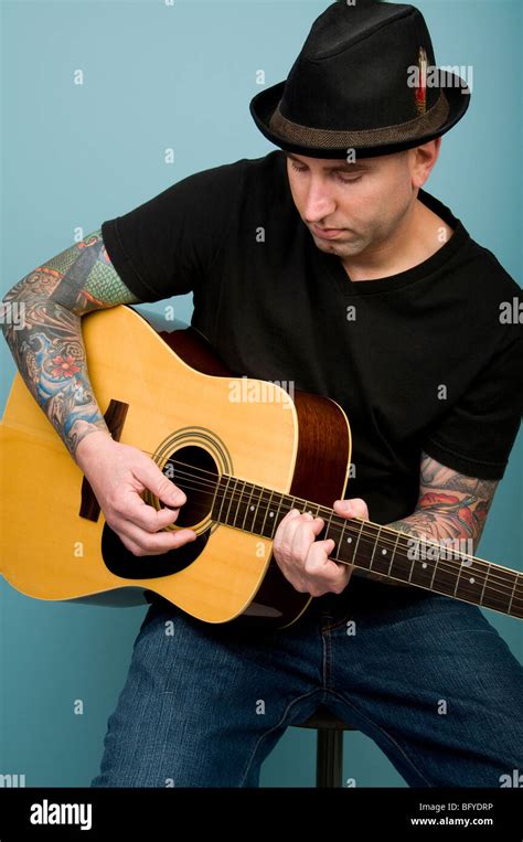 Man with tattoos playing guitar Stock Photo - Alamy