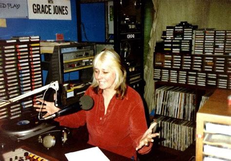 a woman sitting in front of a record player holding a microphone and ...