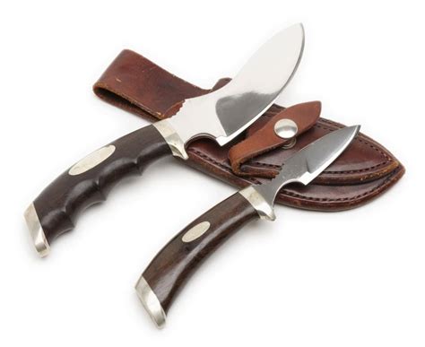 Set of 2 skinning knives in leather combo sheath marked “Track Knives/Whit