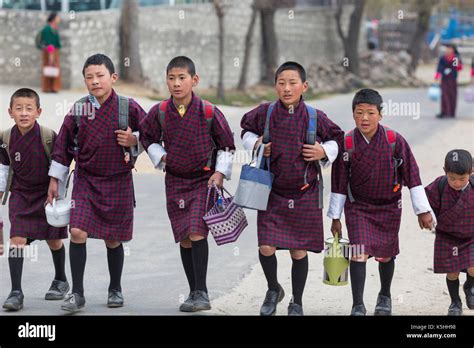 Schoolchildren on their way to the town school wearing traditional ...