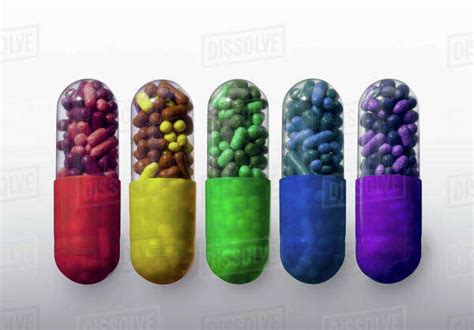 A row of vibrantly variously colored capsule pills, close-up - Stock ...